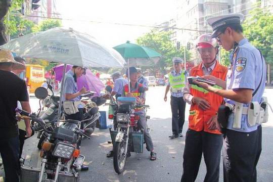 加装遮阳伞存在潜在危险 增城区交警对摩托车主进行处罚和安全教育